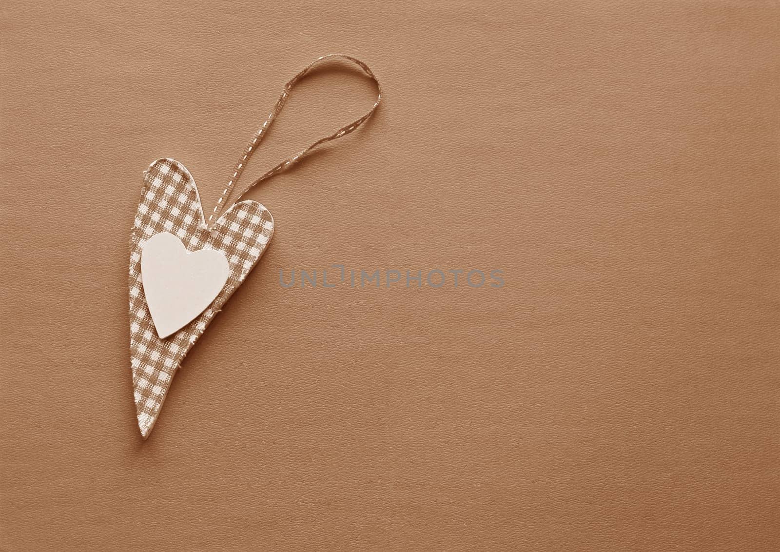 A fabric heart in Peach Fuzz on a paper background