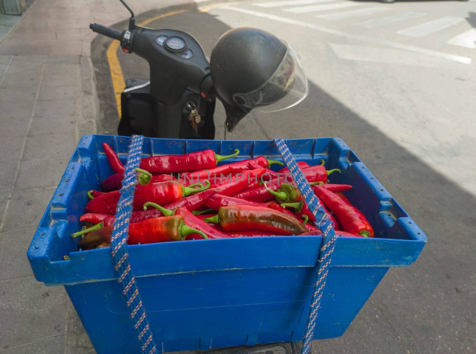 Peasant scooter loaded with tail luggage box full of red guindas. This variety is highly appreciated for traditional pig slaughter.
