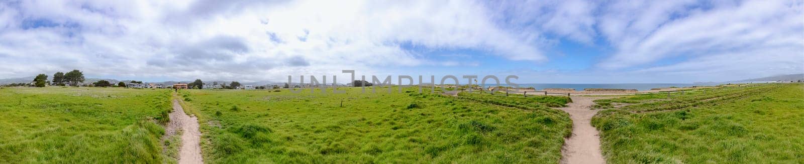 scenic green landscape at half moon bay with wooden houses at horizon, California, USA