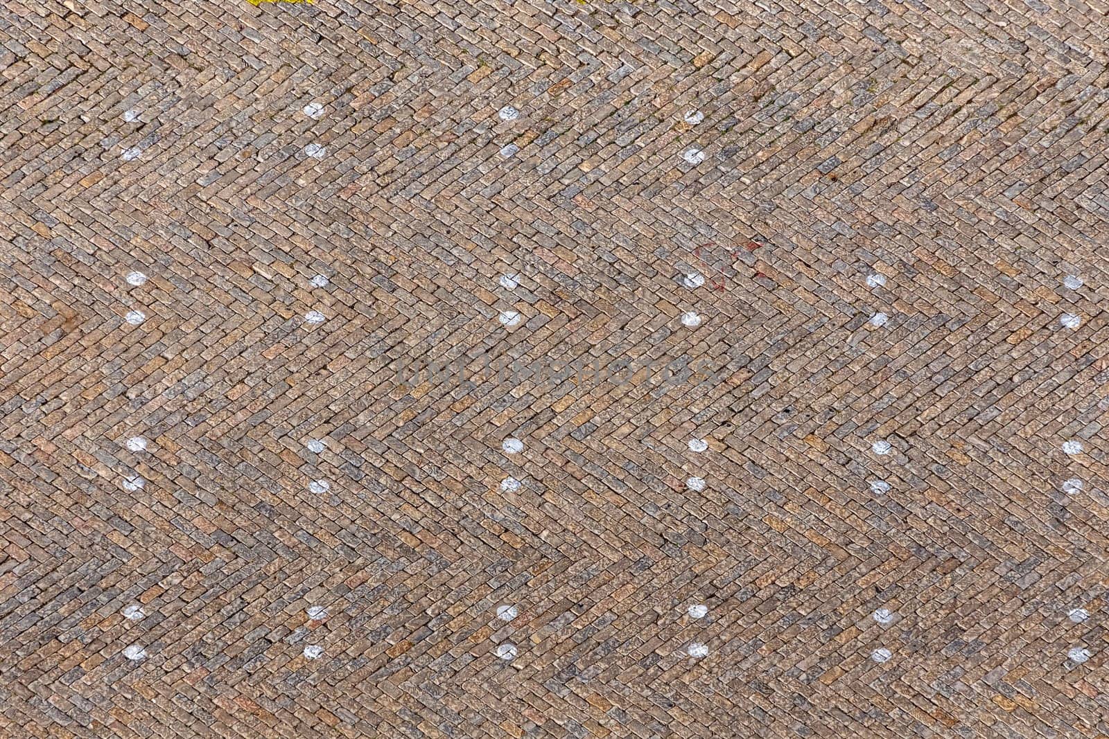 old brick pattern of old market square with markers for car parking gives a harmonic background