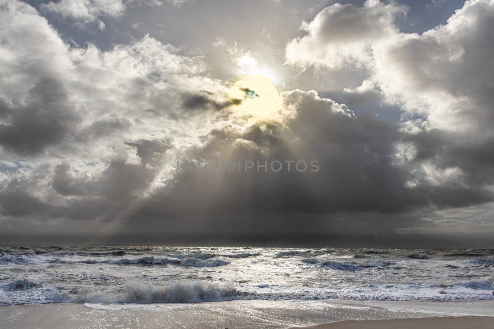 sea landscape with huge waves and sunbeam at the island of Sylt, Germany
