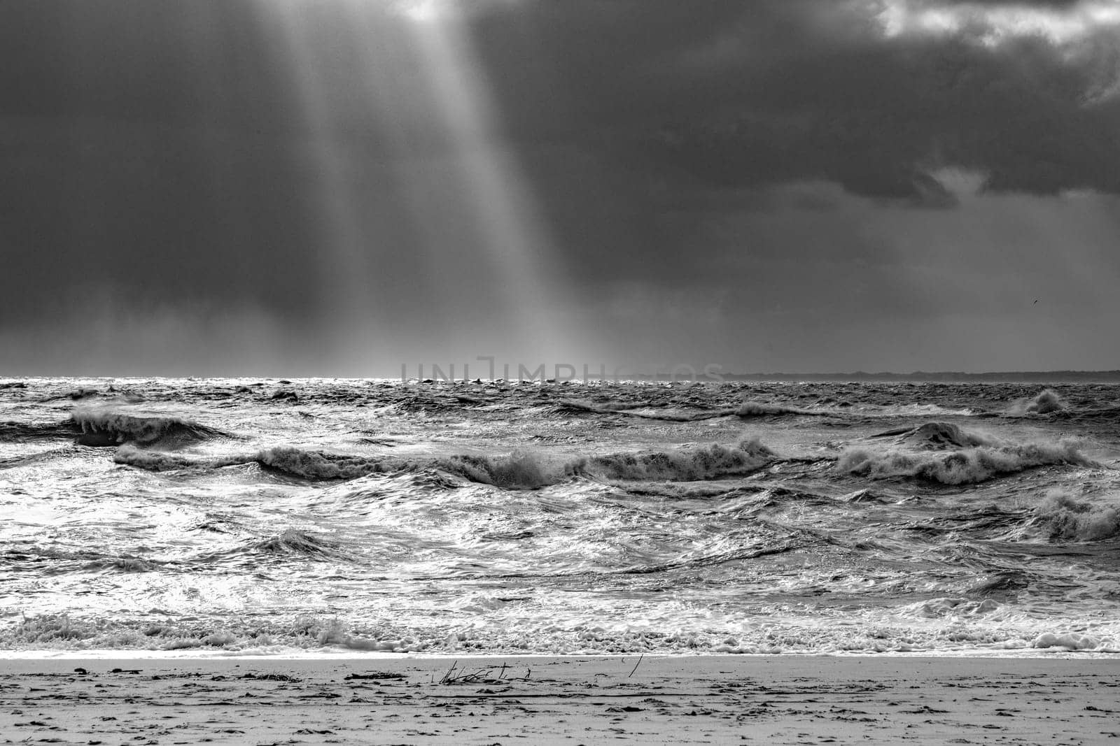sea landscape with huge waves and a lightbeam in Sylt, Germany