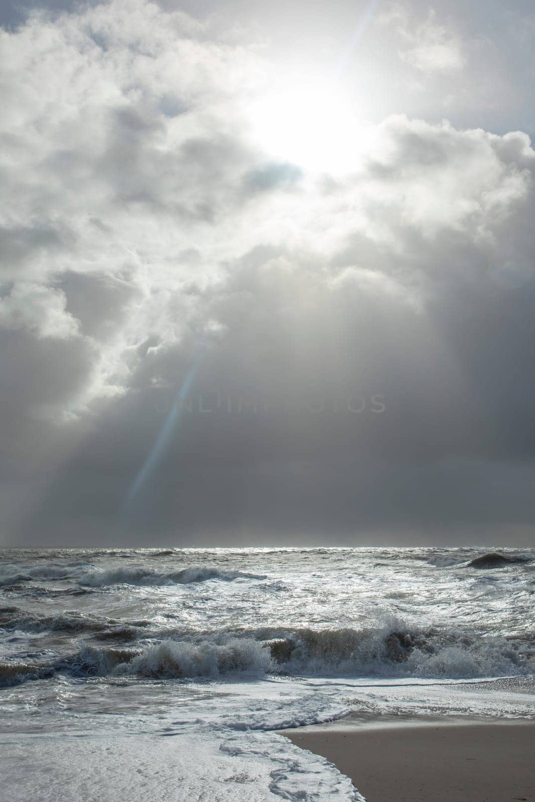 sea landscape with huge waves and a lightbeam in Sylt, Germany
