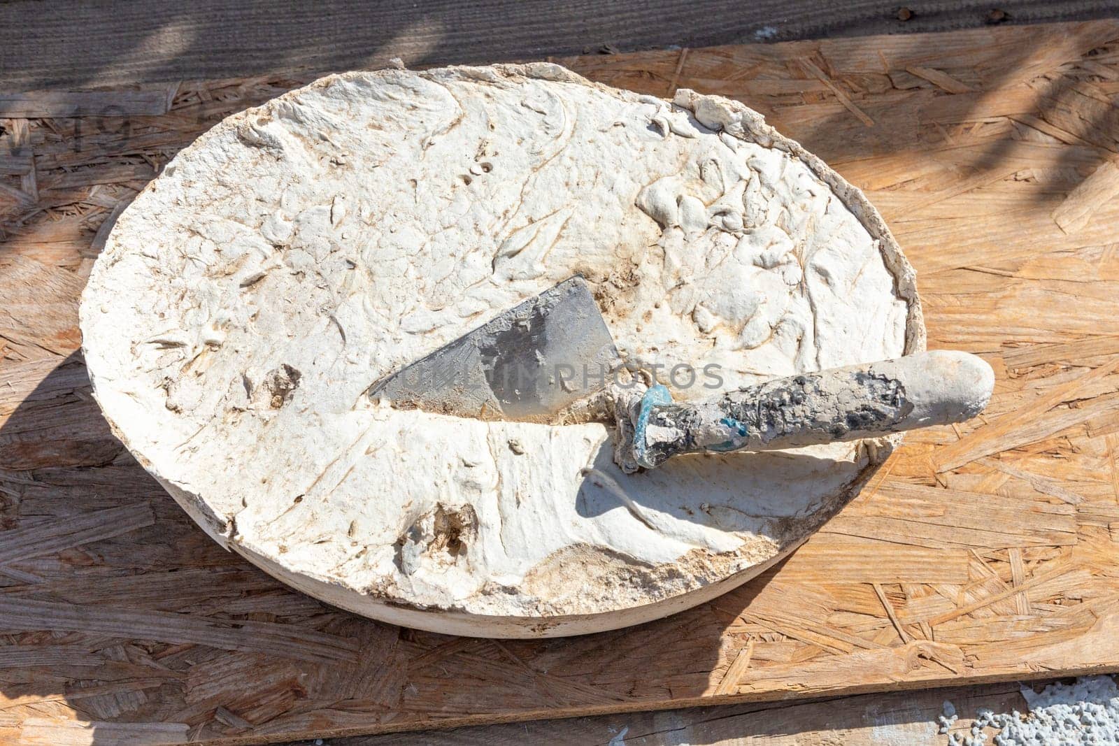 hand whose in a bucket with dried concrete as symbol for a construction site