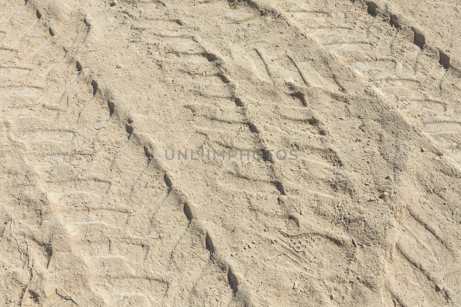 marks of a huge digger in the sand of the construction site