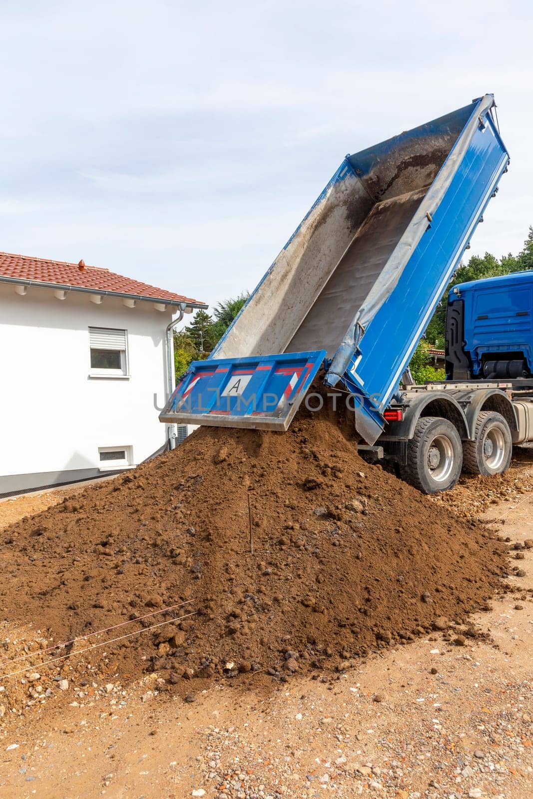 unloading the truck with potting soil from the truck bed at the construction site in Germany
