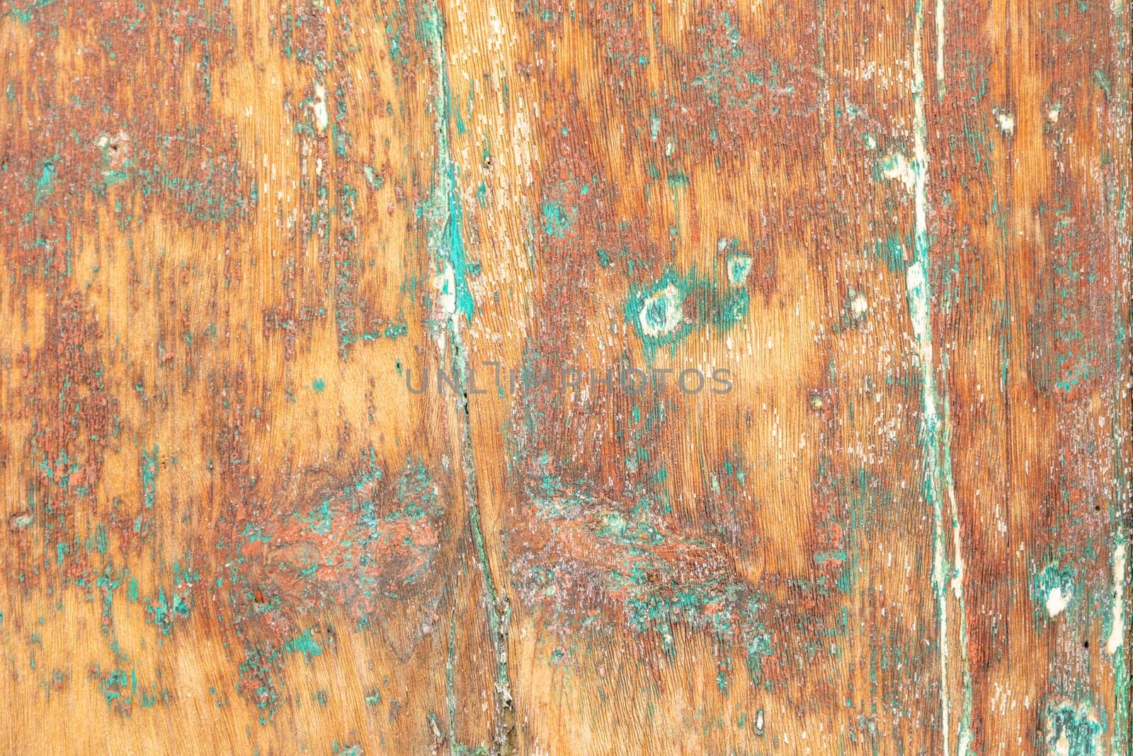 pattern of grunge wall in different colors on a wooden background with peeling old paint