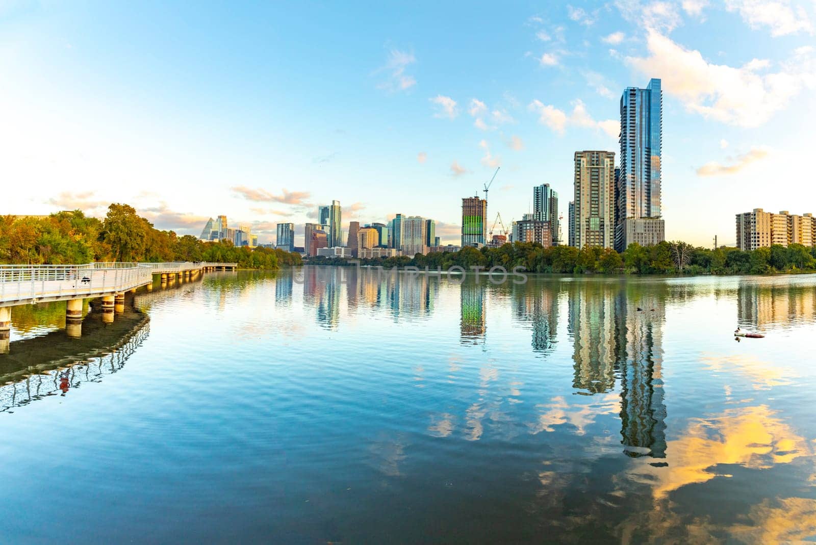 skyline of Austin in early morning light with mirroring city in the colorado river, Texas, USA