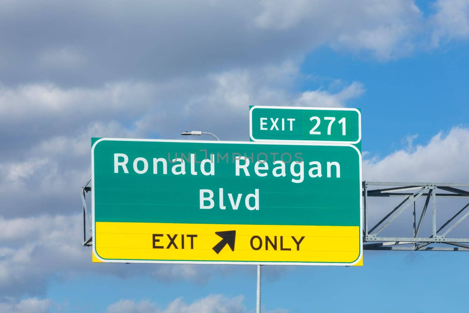 exit Ronald Reagan boulevard from interstae 35 with traffic in afternoon sun with clouds