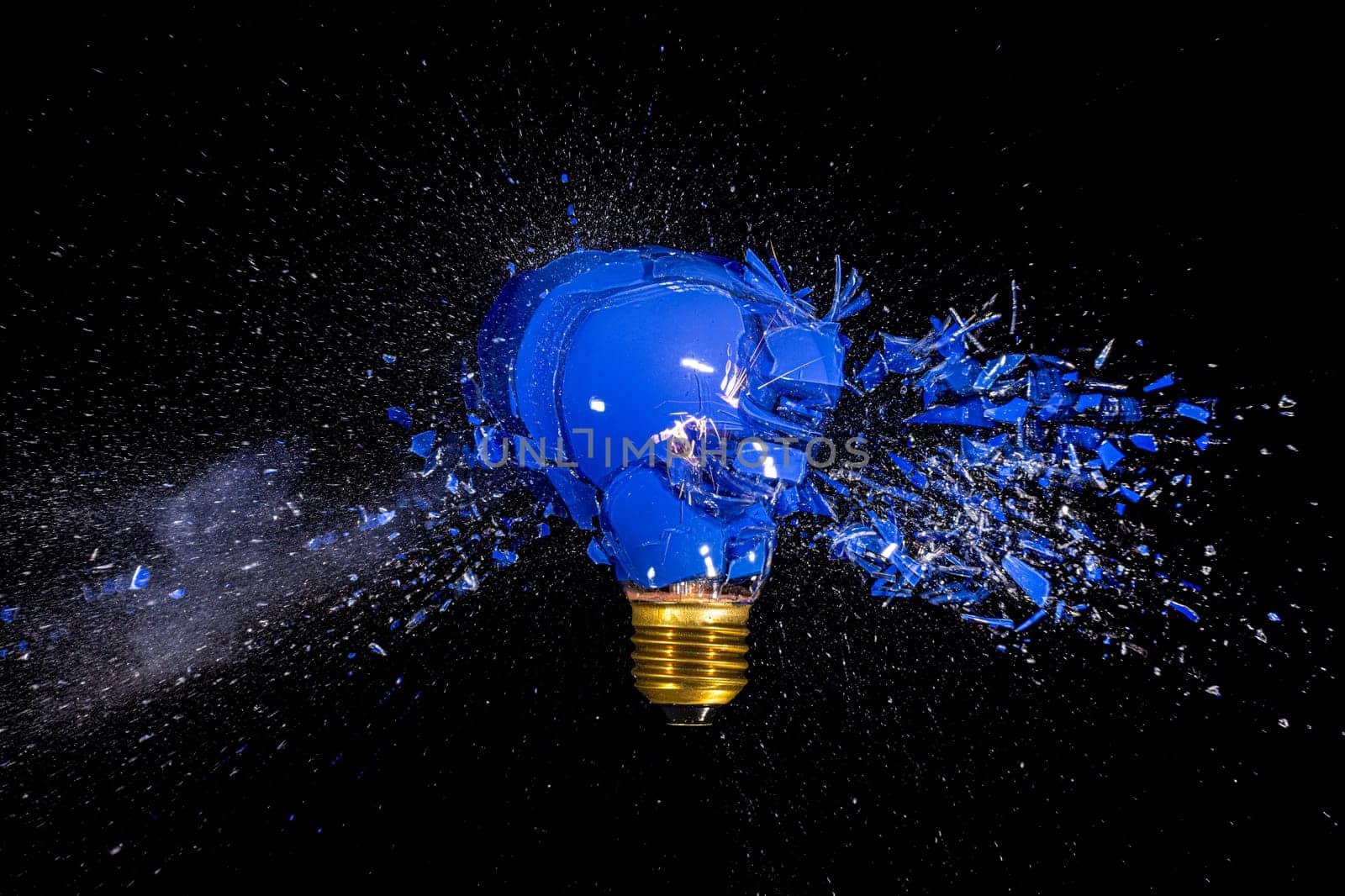 traditional blue bulb breaks and explodes on a black background. high-speed photography