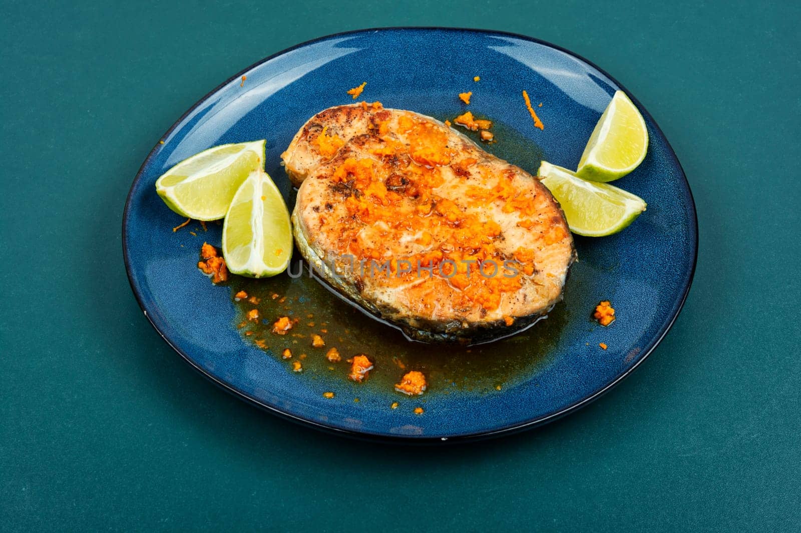 Roasted salmon or trout steak with orange and lime sauce. Top view.