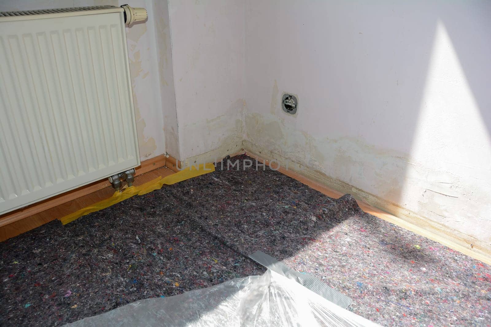 A room in an apartment during renovation with the floor taped off to protect it from paint and paste