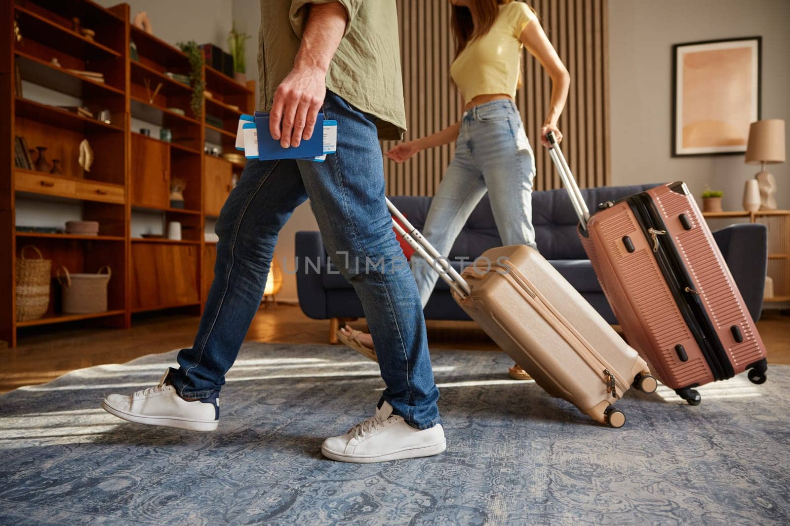 Closeup man and woman walking with luggage and travel documents leaving home. Family couple travelling together