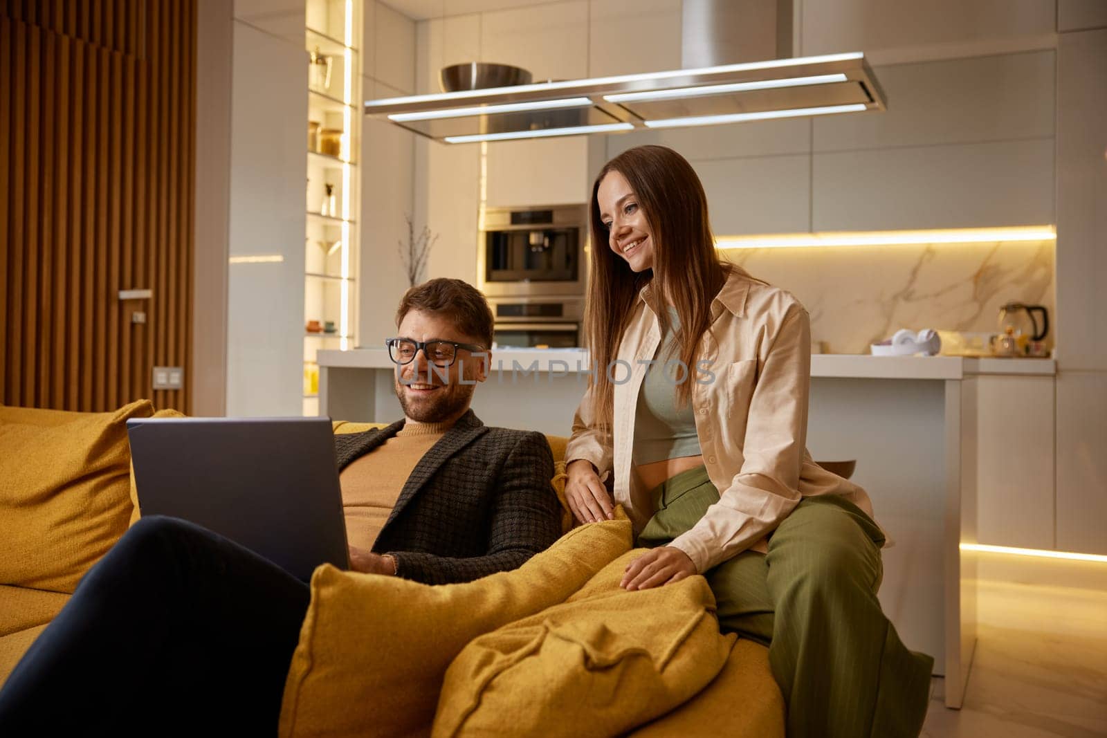 Happy family couple having nice conversation with friends or relatives using online video call chat on laptop computer and modern wireless technology