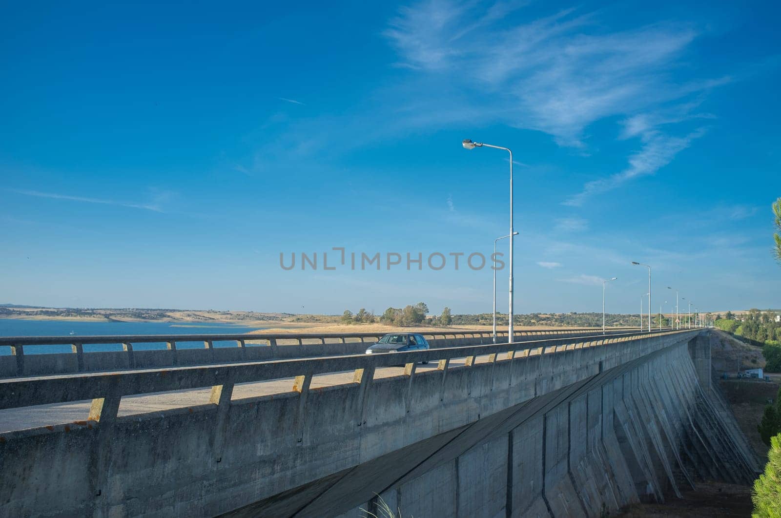 Car crossing over Barragem do Caia road, Campo Maior, Alentejo, Portugal. Buttresses side view