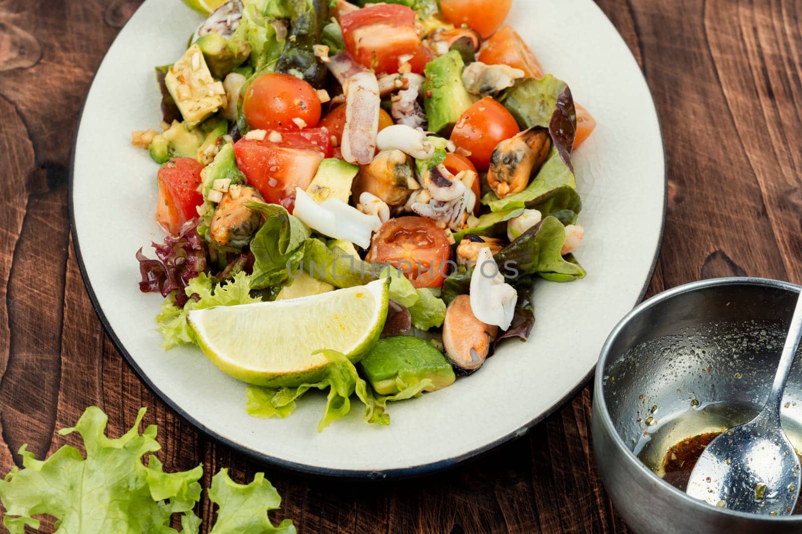 Delicious salad with fresh vegetables and seafood on a plate. Space for text.