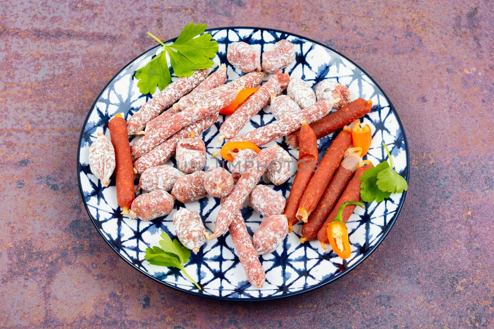 Assortment of salami sausage on a plate, meat appetizer. Space for text.