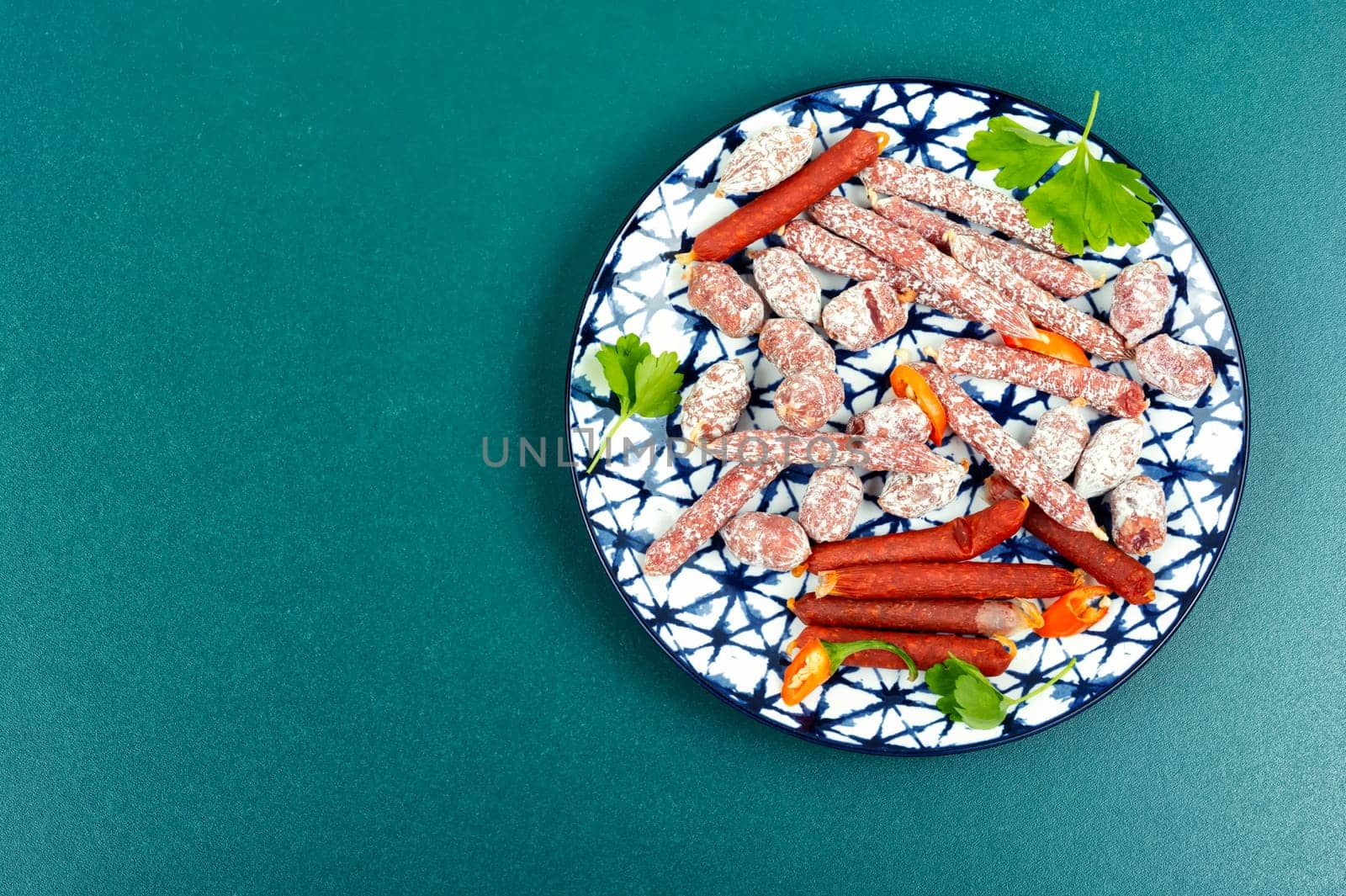 Assortment of salami sausage on a plate, meat appetizer. Space for text.