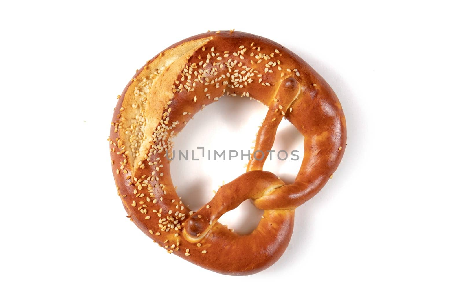 Golden brown Bavarian pretzel with a generous amount of sesame seeds sprinkled over it, from above on a white background. The pretzel's knotted shape and crispy texture are enticing and visual appeal