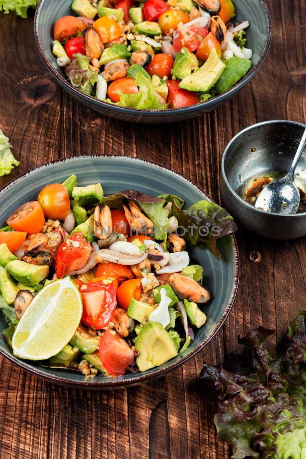 Tasty salad with mix of vegetables, seafood and fresh green lettuce in a bowl.