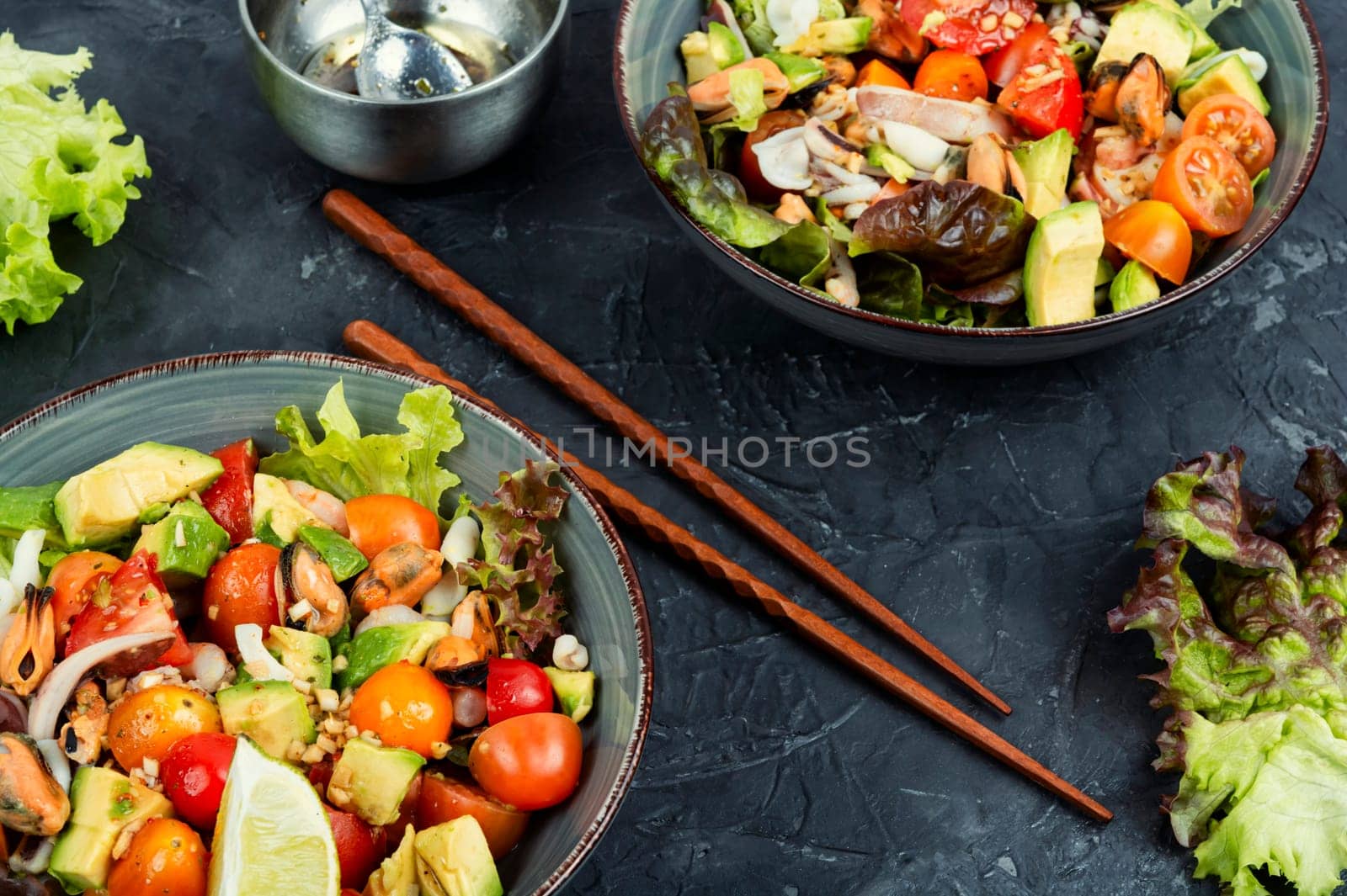 Tasty salad with mix of vegetables, seafood and fresh green lettuce in a bowl.