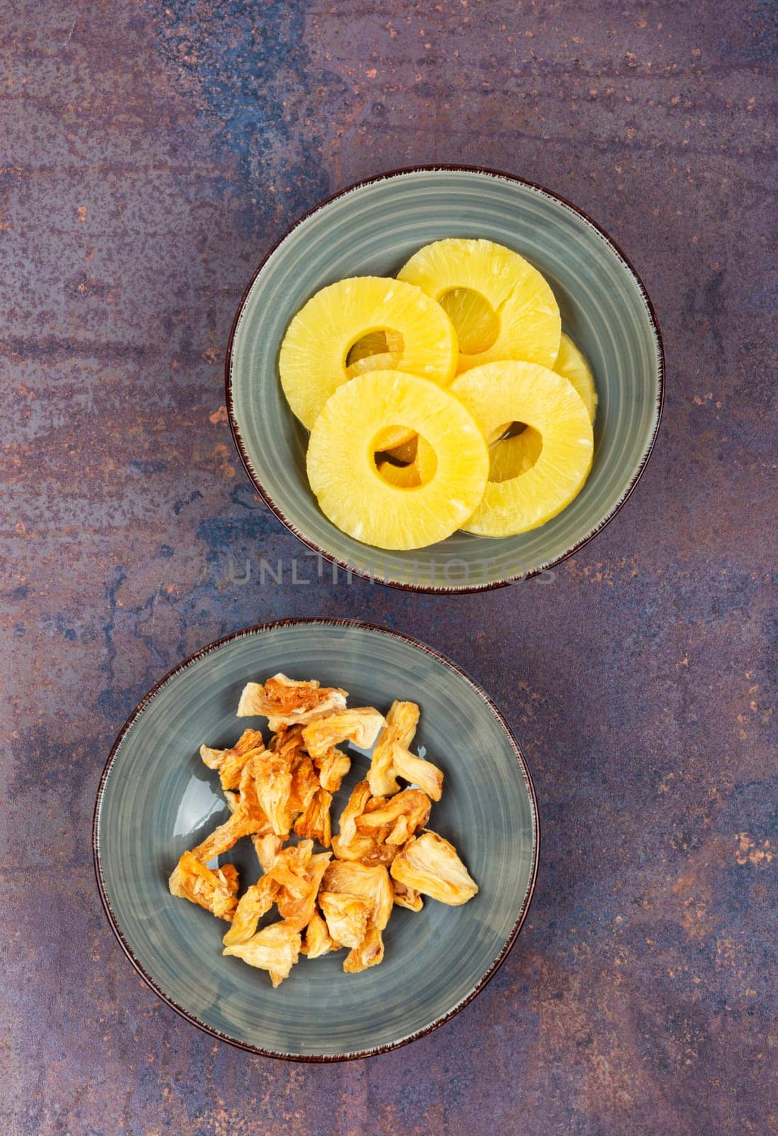 Delicious dry and fresh pineapples in bowls. Candy pineapples or ananas.