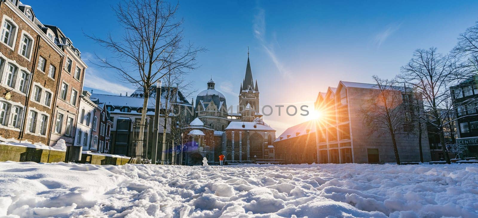 The famous Huge gothic cathedral of The Emperor Karl in Aachen Germany during winter season with snow at Katschhof against blue sky and sunshine background