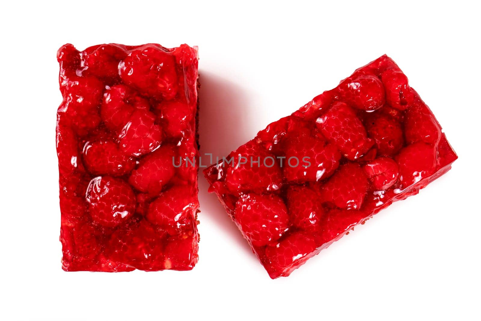 Two golden brown raspberry tarts, freshly baked and glistening with a generous layer of raspberry jam. The tarts are generously filled with plump raspberries, creating a beautiful burst of flavor and color. The tarts are displayed on a white background, showcasing their vibrant appearance