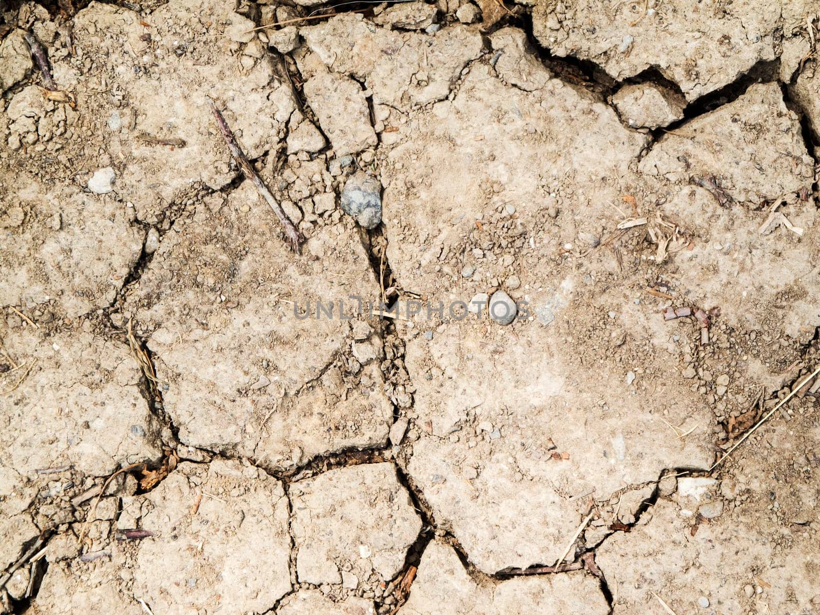 Cracked dried sand surface top view in daylight.