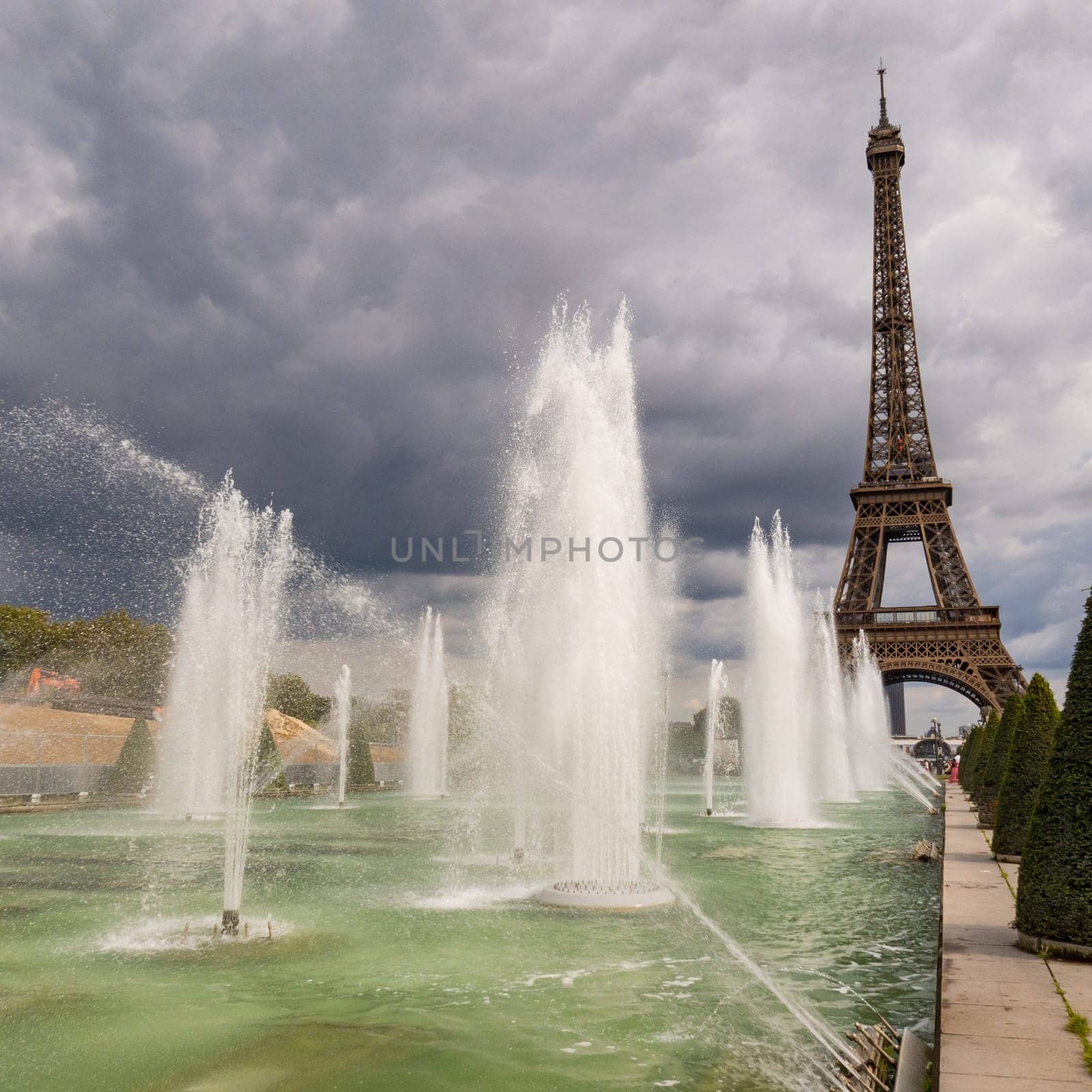 Paris, France - August 29 2023: Eiffel tower seen from Trocadero Fountains in a cloudy day. Squared  photography taken in Paris.