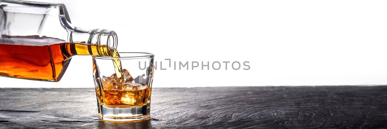 Whiskey being poured into a glass from a bottle on a white background. AI generated