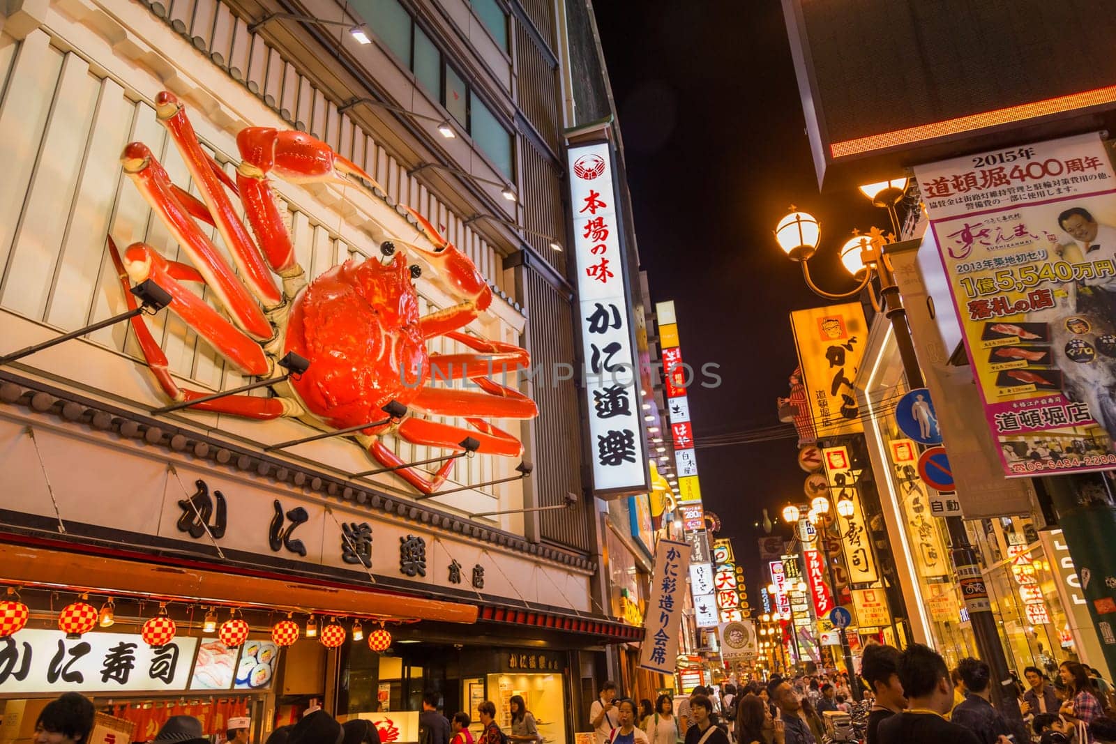 Osaka, Japan - August 2, 2020: Tourist walking in a shopping street called Dotonbori Street. Giant moving crab on restaurant in Dotonbori Osaka
