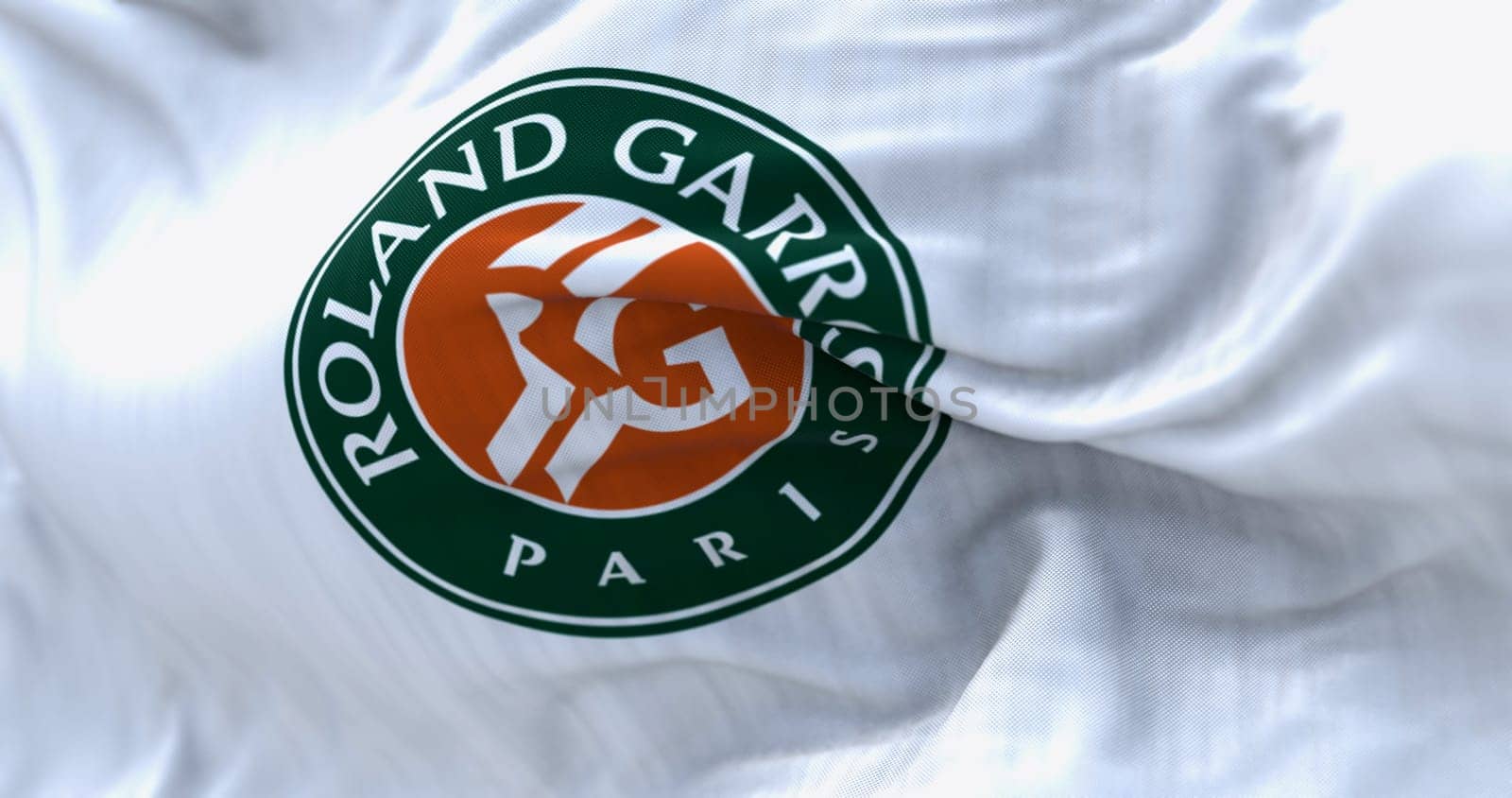 Paris, FR, Apr. 2023: White flag with Roland Garros logo waving in the wind. French Open is a major tennis tournament scheduled in late May each year. Illustrative editorial 3d illustration render