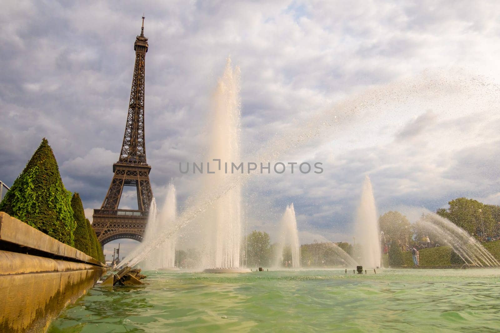 Paris, France - August 29 2023: Eiffel tower seen from Trocadero Fountains in a cloudy day. Photography taken in Paris.