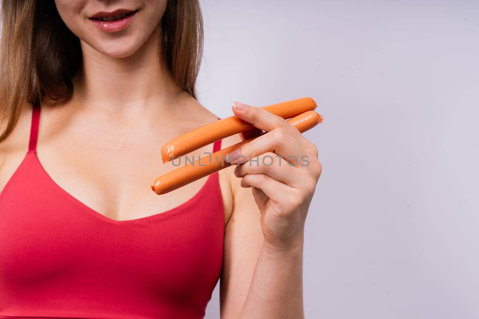Woman opened her mouth and wants to bite off a sausage, close-up