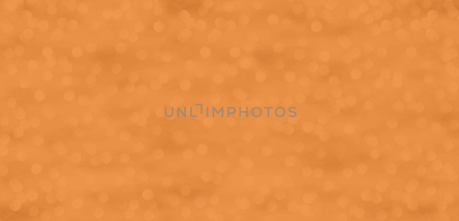 A glittering background with dots of light in Peach Fuzz