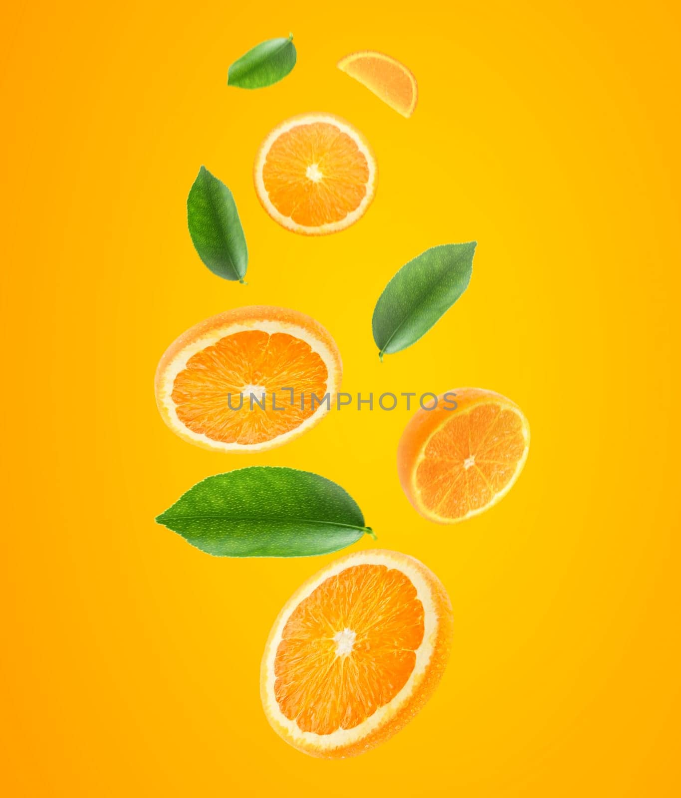 Falling juicy oranges with green leaves on orange background. Flying defocusing slices of oranges. Applicable for fruit juice advertising