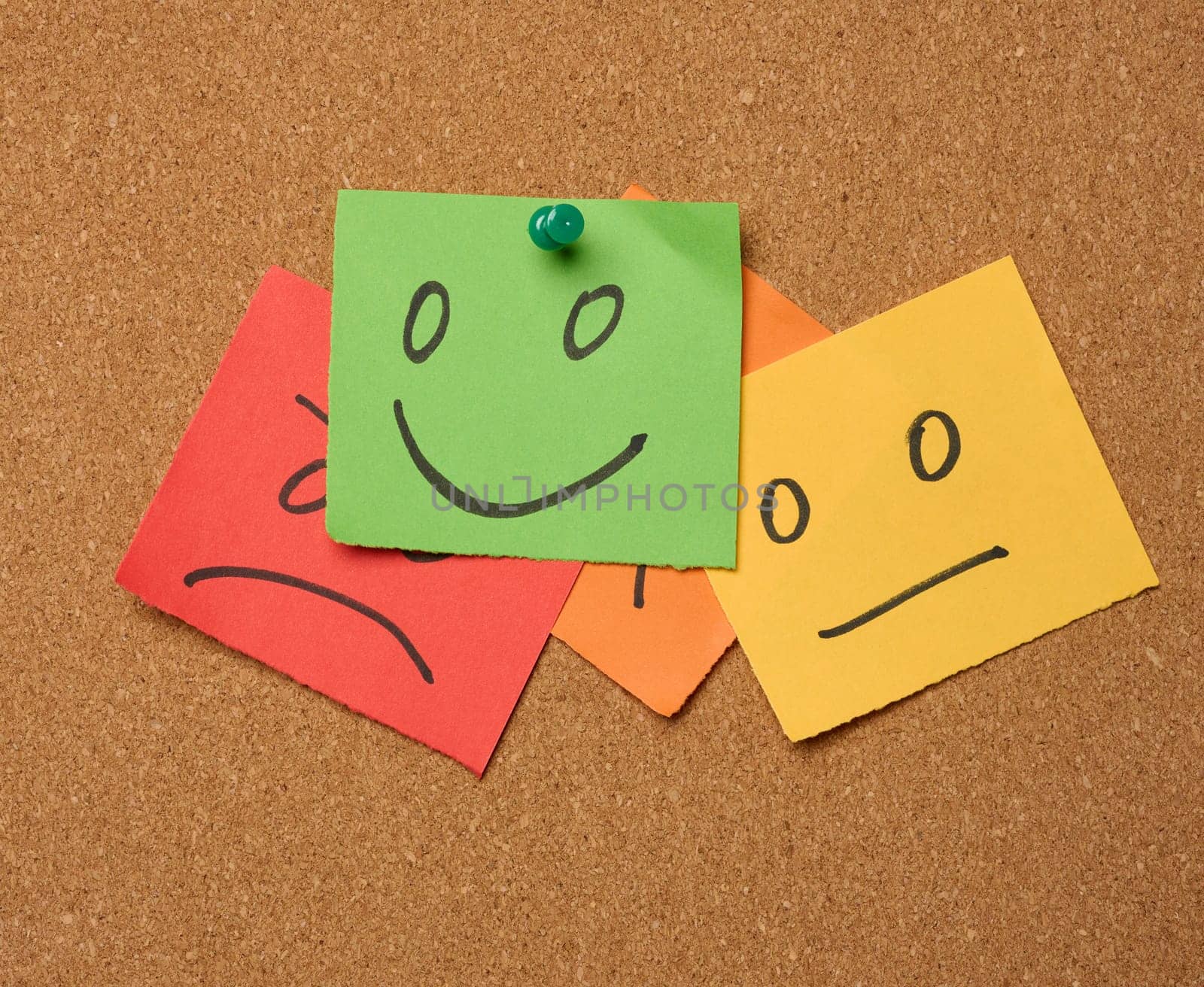 Drawn faces with different emotions on a sticker and attached to a cork board. Rating and quality assessment