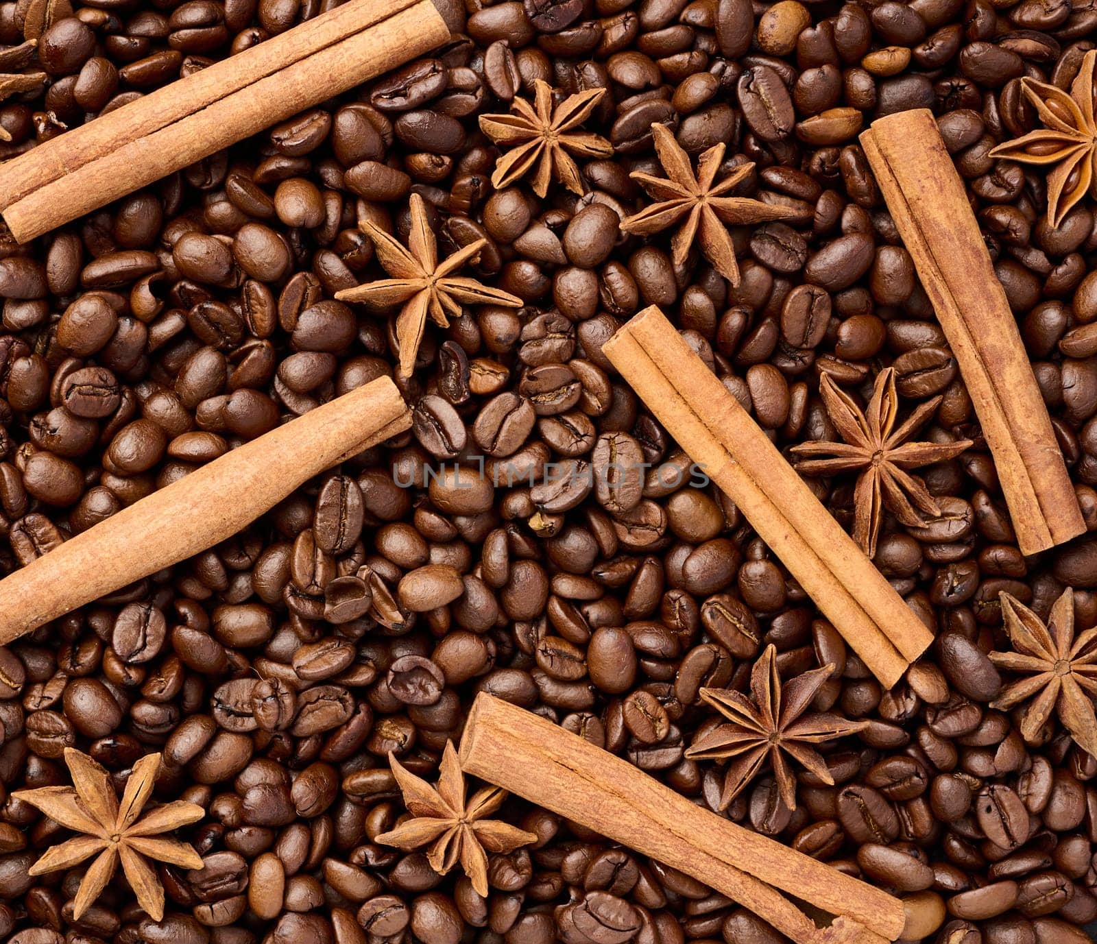 Roasted coffee beans, cinnamon sticks and star anise, full frame