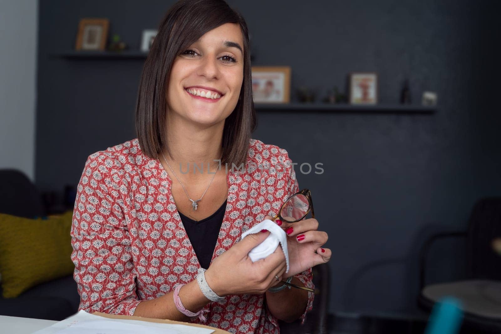 a young woman cleaning her glasses