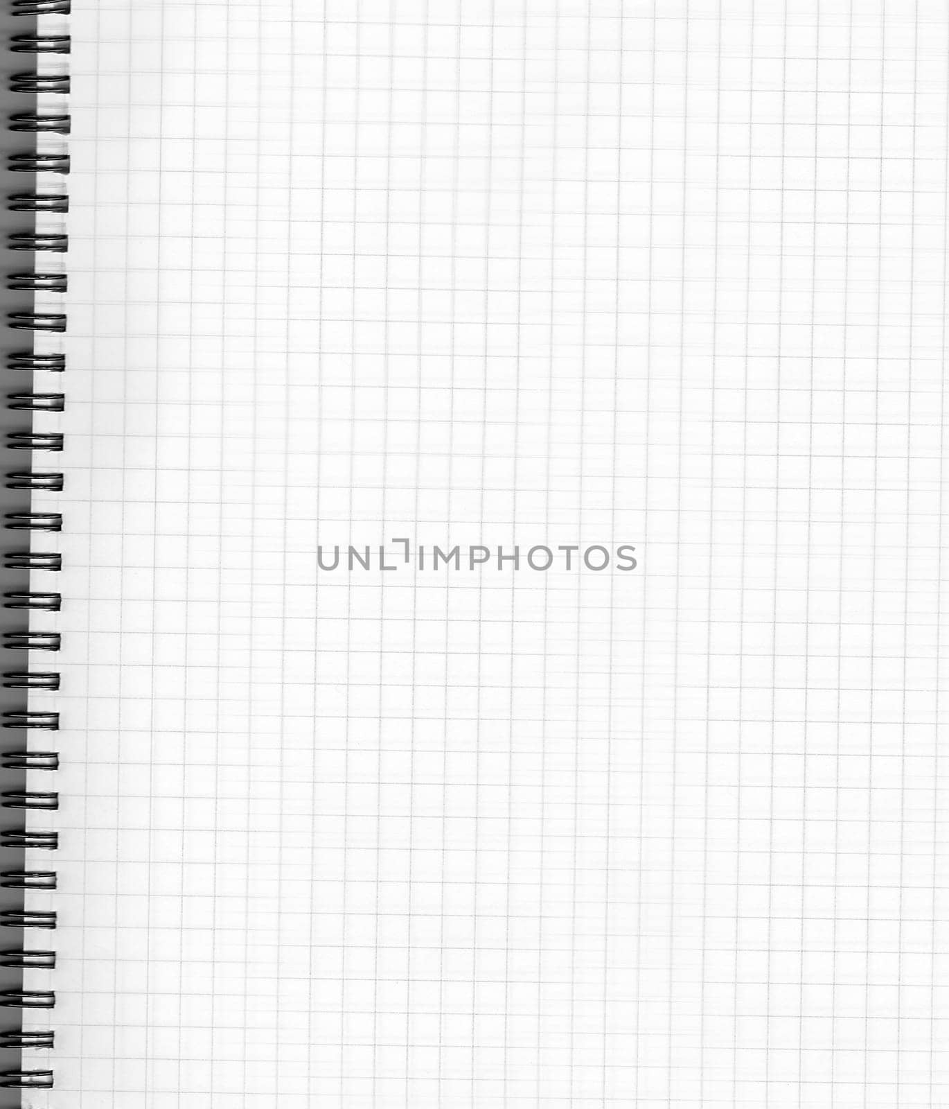 A white notebook on a spread with a checkered sheet, a close-up view from above