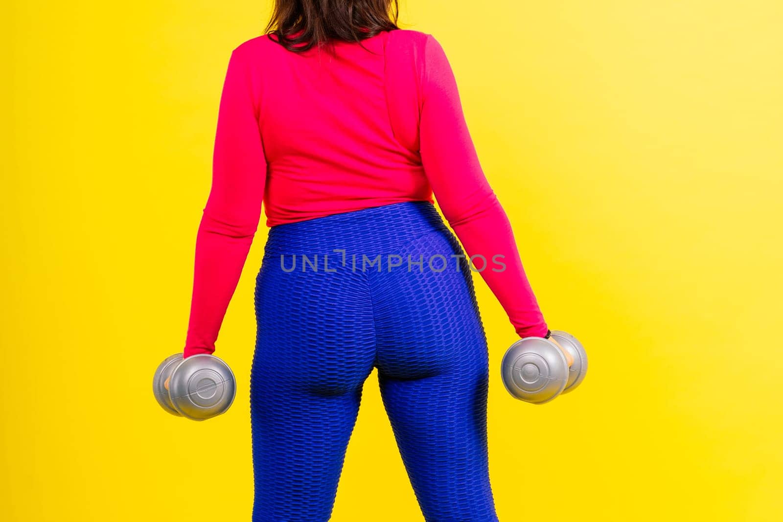 Young smiling happy chubby overweight plus size big fit woman warm up training hold dumbbells