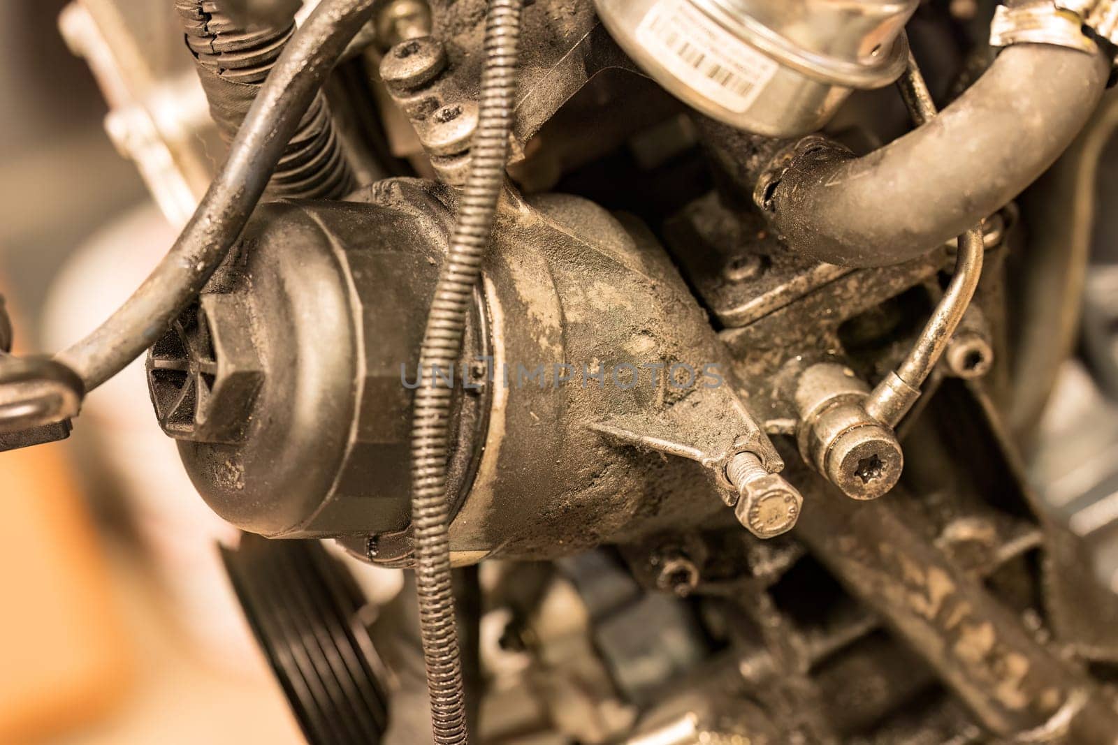 Close-up photo of a dirty oil filter in a car engine, highlighting the need for regular maintenance.