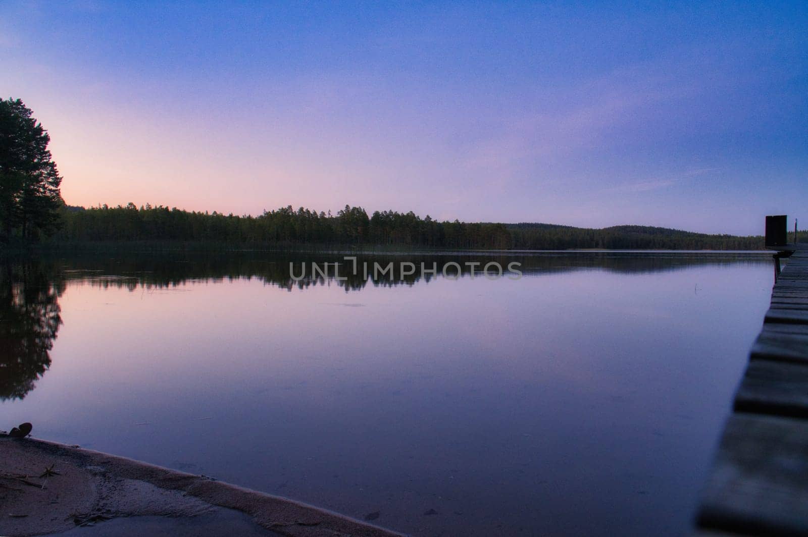 Sunset on a lake in Sweden. Blue hour on calm water. Nature photo from Scandinavia. Landscape shot