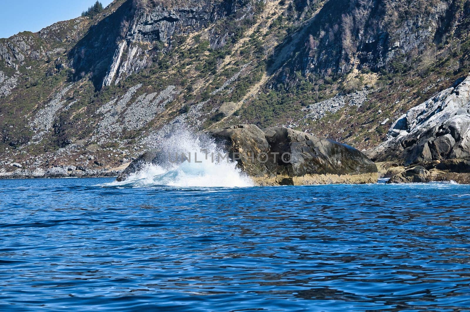 norway on the fjord, spray on rocks. Water splashes on the stones. Coastal landscape in Scandinavia. Landscape photo from the north
