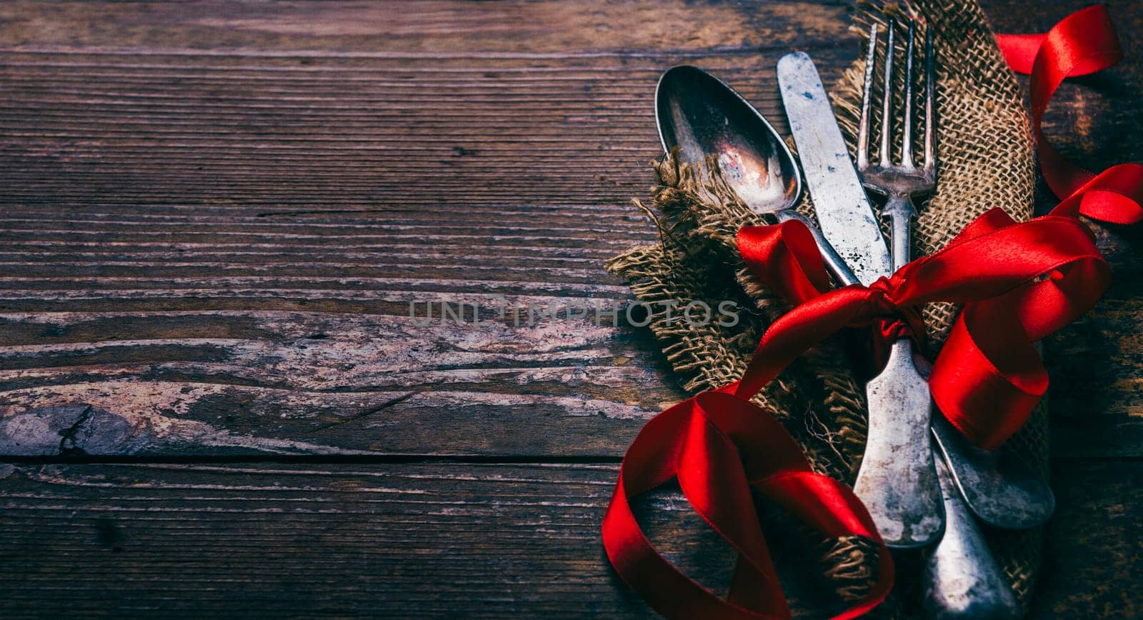 Valentines dinner background with vintage silverware and red ribbon on wooden table. Luxury restaurant menu for romantic celebration event. Valentine day dine.