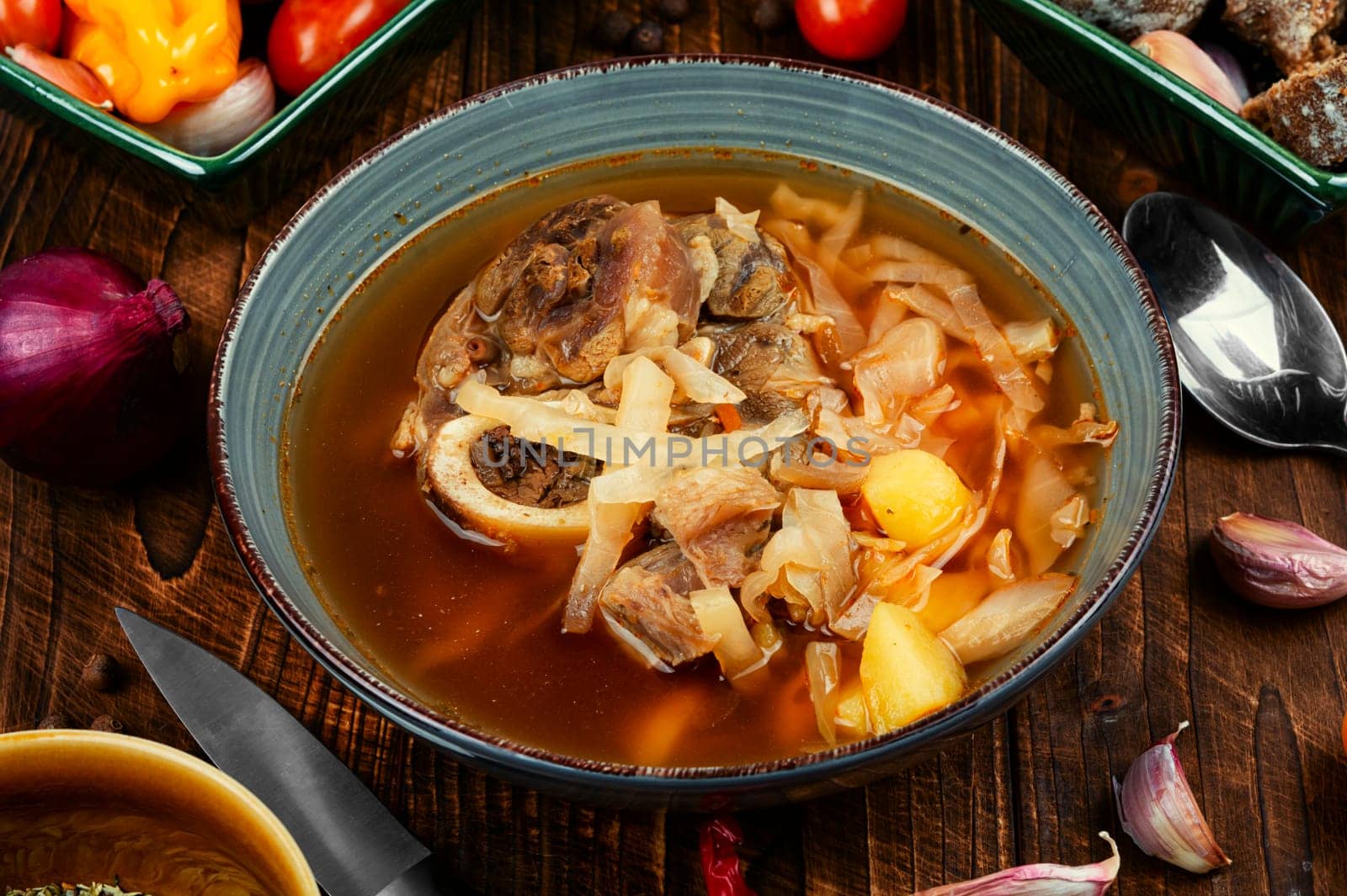 Soup with meat on old rustic wooden table. Traditional Ukrainian borscht. Food recipe.
