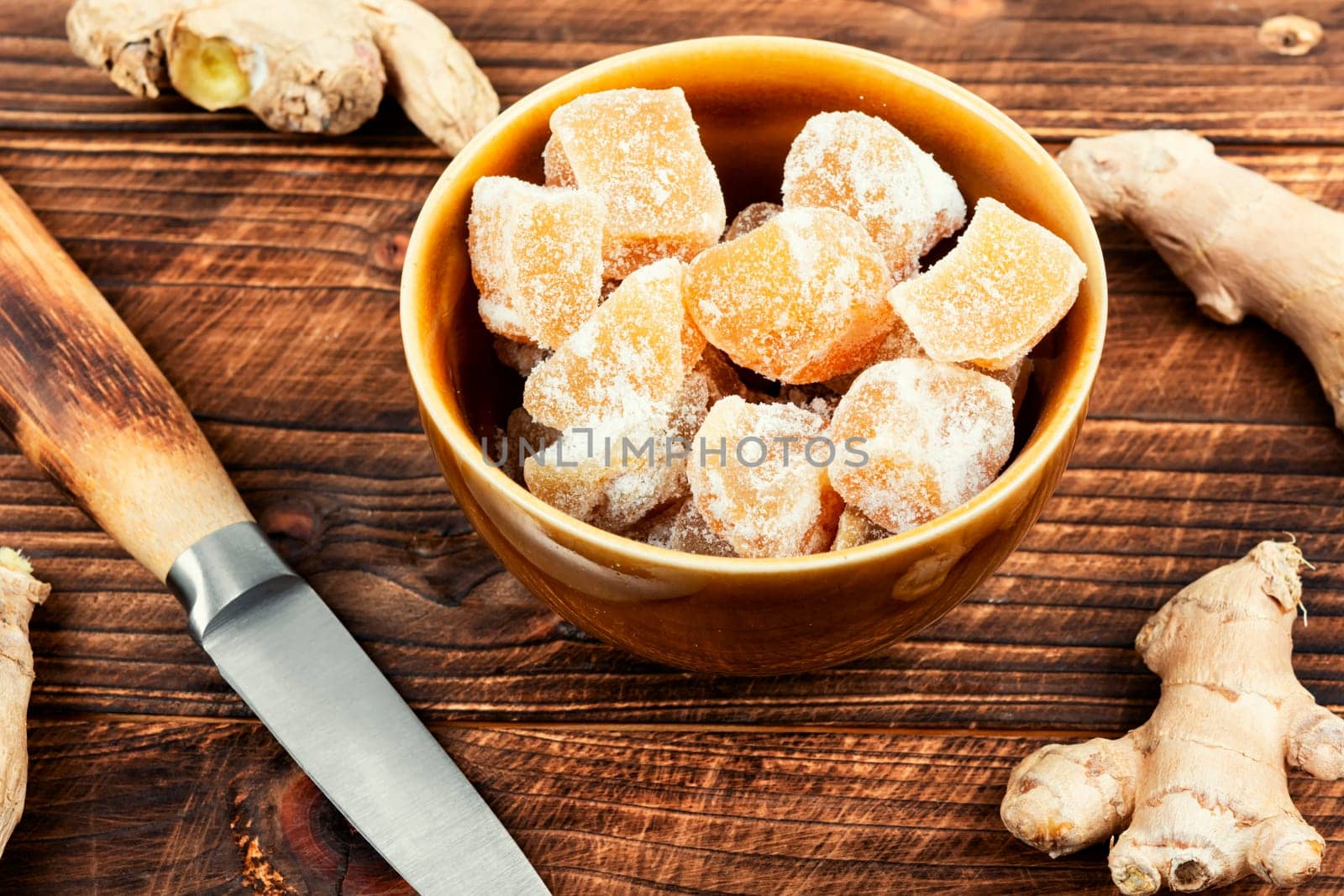 Heap of sweat candied ginger on wooden kitchen table.. Candied ginger cubes. Healthy sweets.