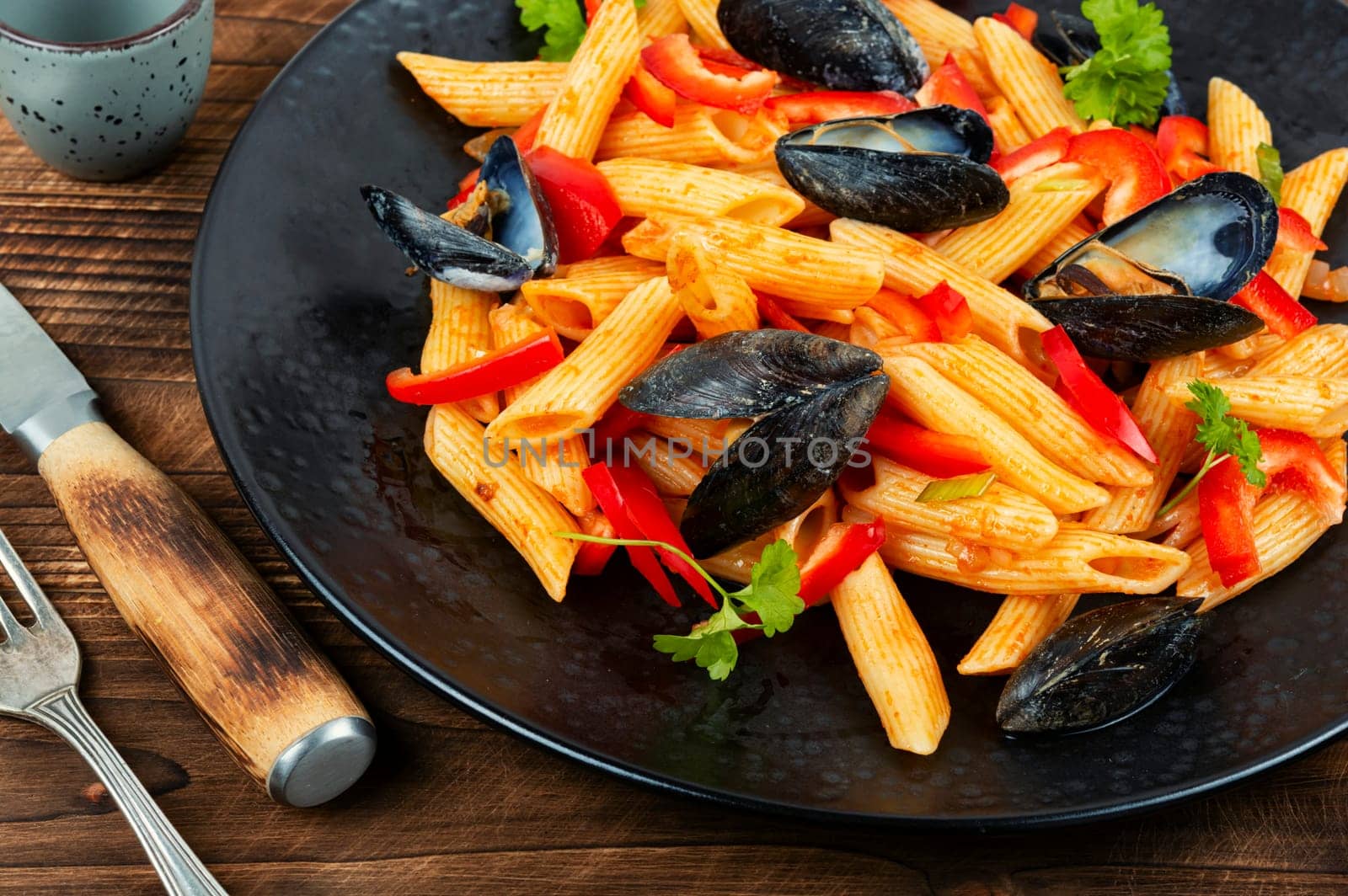 Macaroni vongole with Atlantic mussels, clams on a stylish dark plate. Seafood pasta with clams. Top view