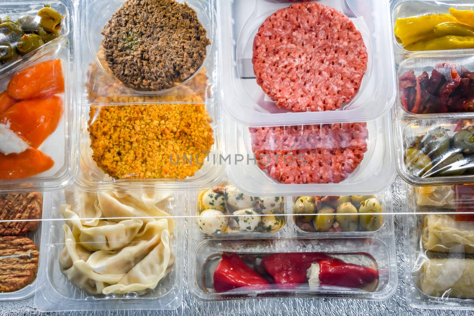 A display of variety of prepackaged food products in plastic boxes.